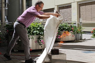 Mitarbeiter löscht Feuer mit Löschdecke