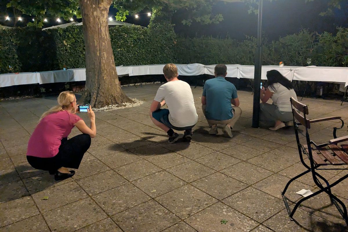 SANTESIS Sommerfest 2025: Mitarbeiter*innen in der Hocke fotografieren Fridulin den Fuchs