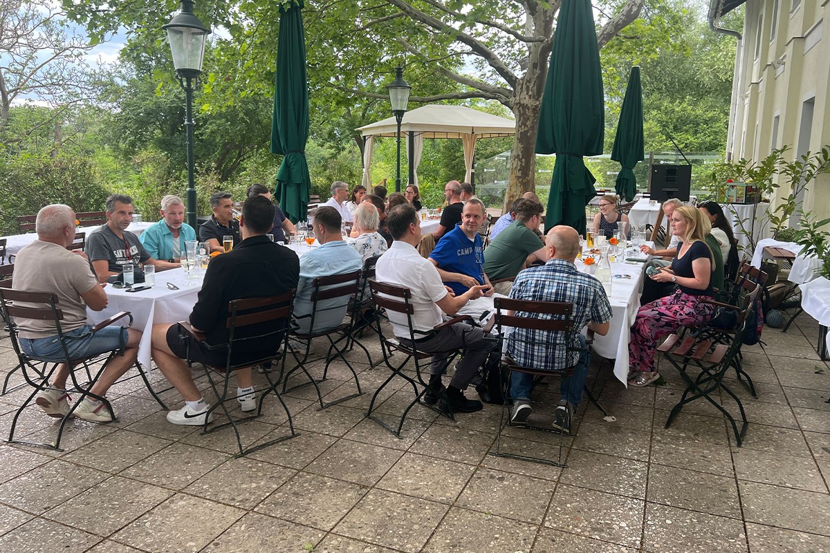 SANTESIS Sommerfest 2025: Mitarbeiter*innen sitzen gemütlich im Gastgarten